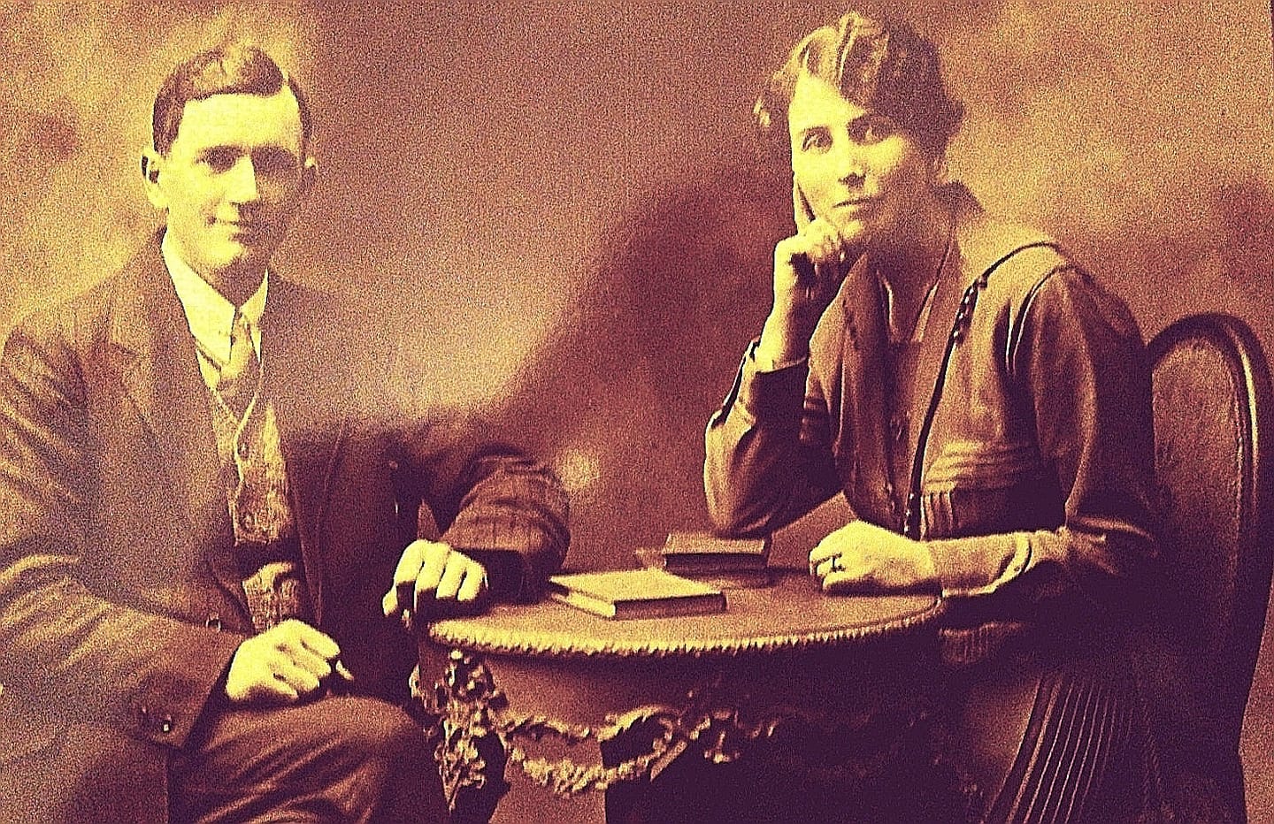 A old photograph of a couple posing for a portrait shortly after they were married - he is in a suit and she is in a dress